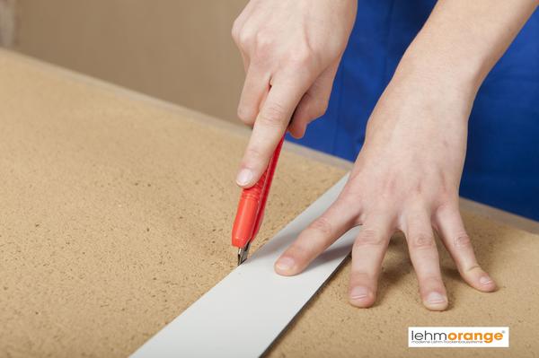 Schneiden der Platten
Die Lehmbauplatten lassen sich ohne Spezialwerkzeuge verarbeiten. Zum Schneiden wir nur ein Messer benötigt. Über der Tischkante oder auf einem Brett  wird dann sauber gebrochen.